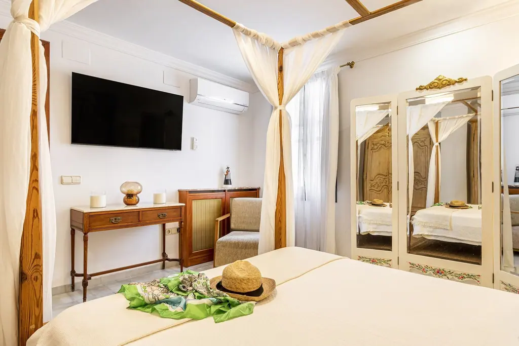 Dormitorio con cama con dosel y aire acondicionado en Villa Paula, Valencia
