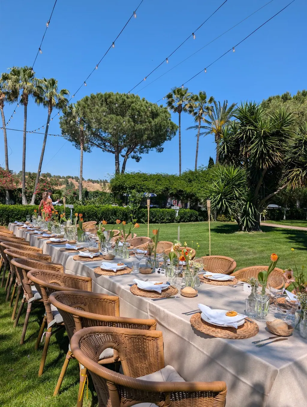Mesa larga puesta en el jardín de Villa Paula para una celebración de grupo